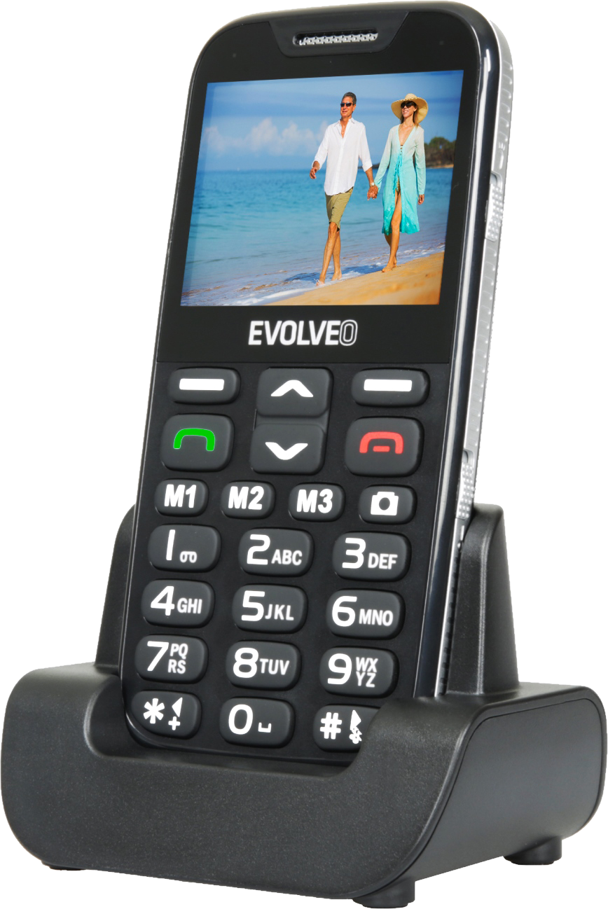 Fekete mobiltelefon fekete töltőalapon, strandfotóval, nagy gombokkal.