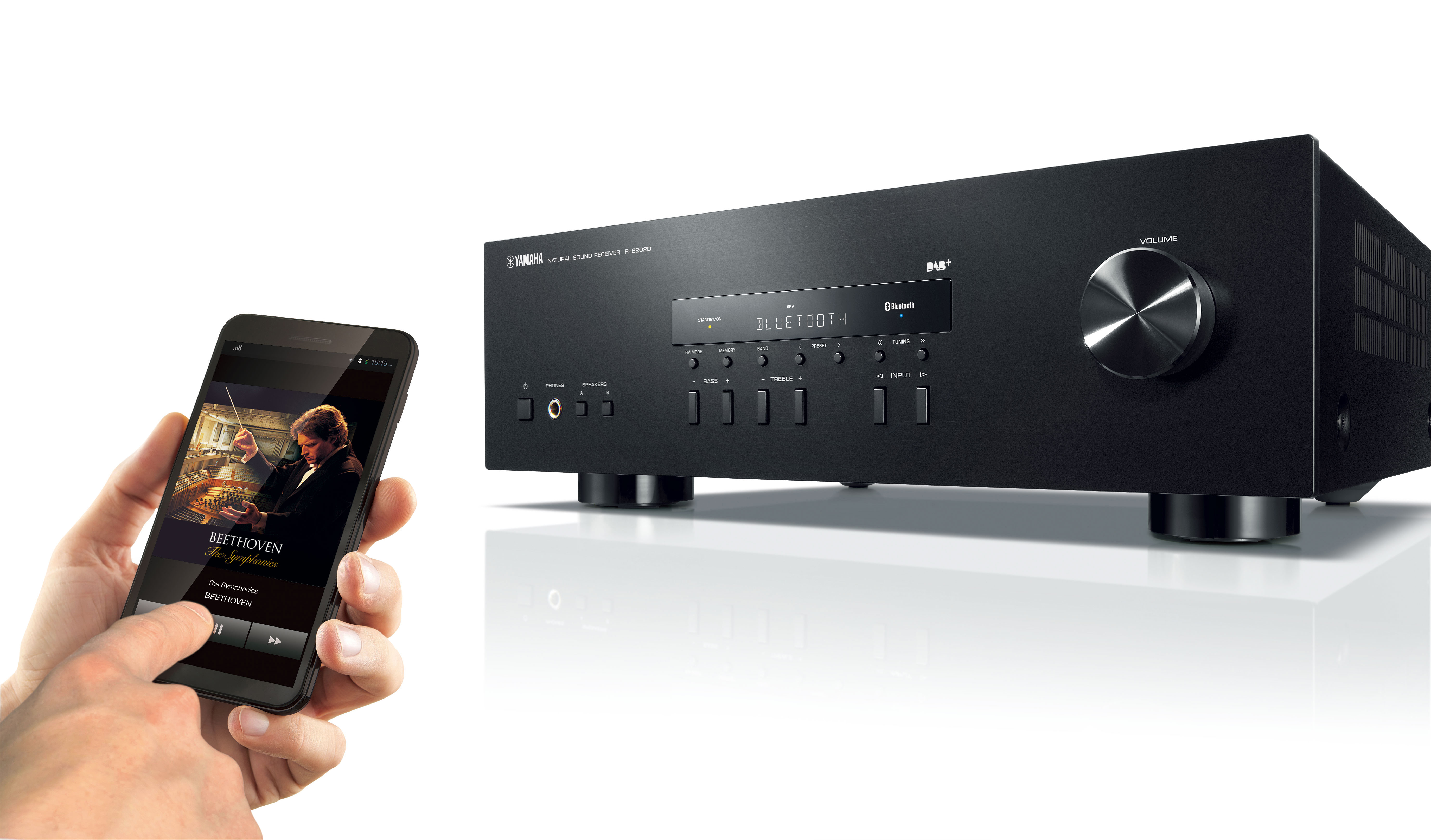 Mann benutzt Telefon neben schwarzem Yamaha Receiver, Telefon zeigt Musik-App.