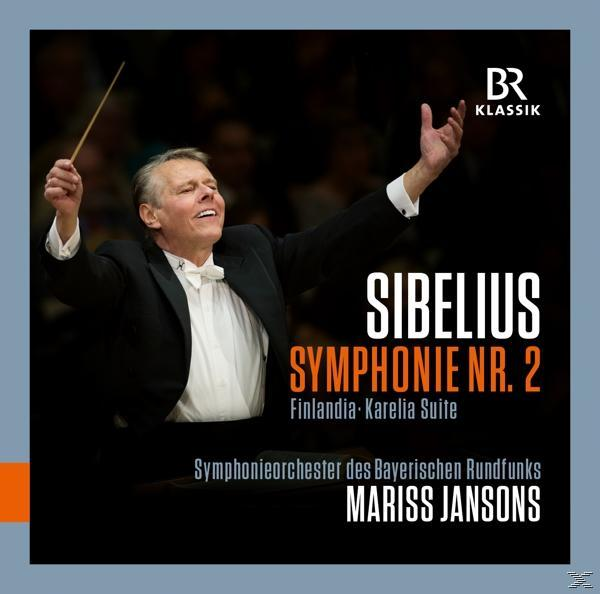 Ein Mann mit erhobenen Armen dirigiert ein Orchester. Text auf Deutsch ist sichtbar.