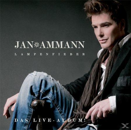 Ein Mann mit Schal sitzt, mit dem Text Jan Ammann und Lampenfieber.