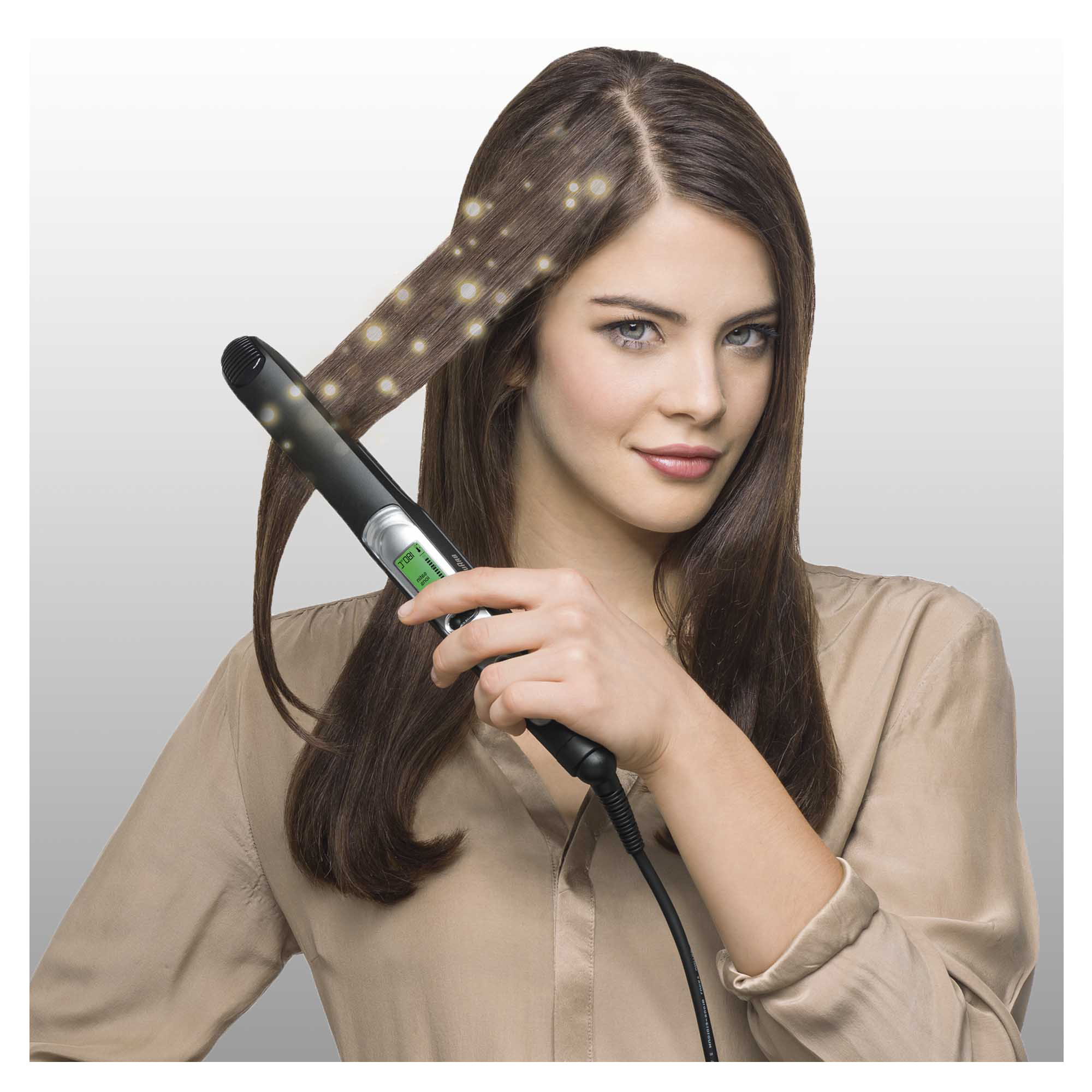 Frau, die einen Haarglätter benutzt. Licht wird auf dem Haar gezeigt.