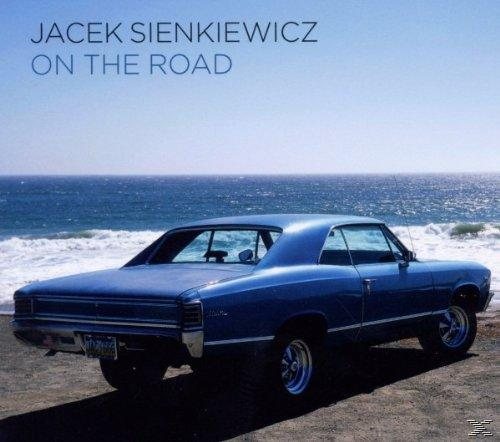 Albumcover eines blauen Autos am Strand.