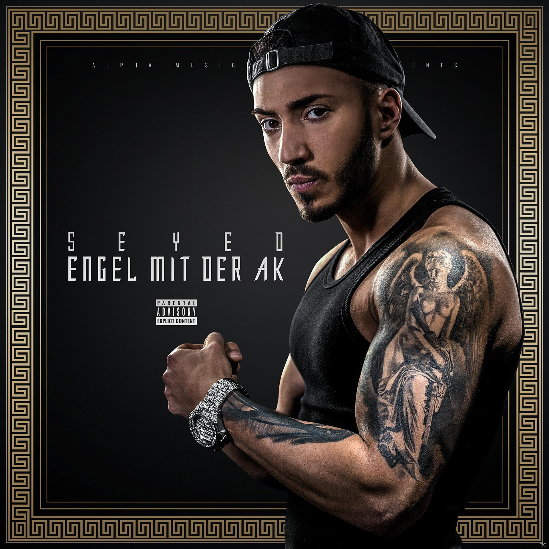 Albumcover mit einem Mann in einem schwarzen Tanktop mit Tätowierungen. Der Titel ist in Gold.
