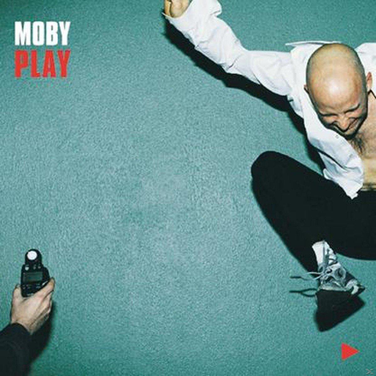 Moby springt in de lucht naast een persoon die een meter vasthoudt. Tekst: Moby Play.