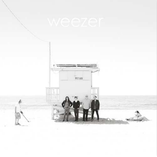 Photo en noir et blanc d'une scène de plage avec un poste de sauveteur et le groupe Weezer.