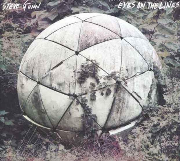 Albumhoes. Een gebroken, verweerde bol in een natuurlijke omgeving, met de tekst "Eyes on the Lines".