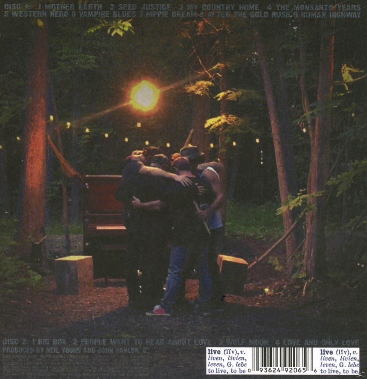 Albumcover: Menschen umarmen sich im Wald, mit einem Scheinwerfer im Hintergrund.