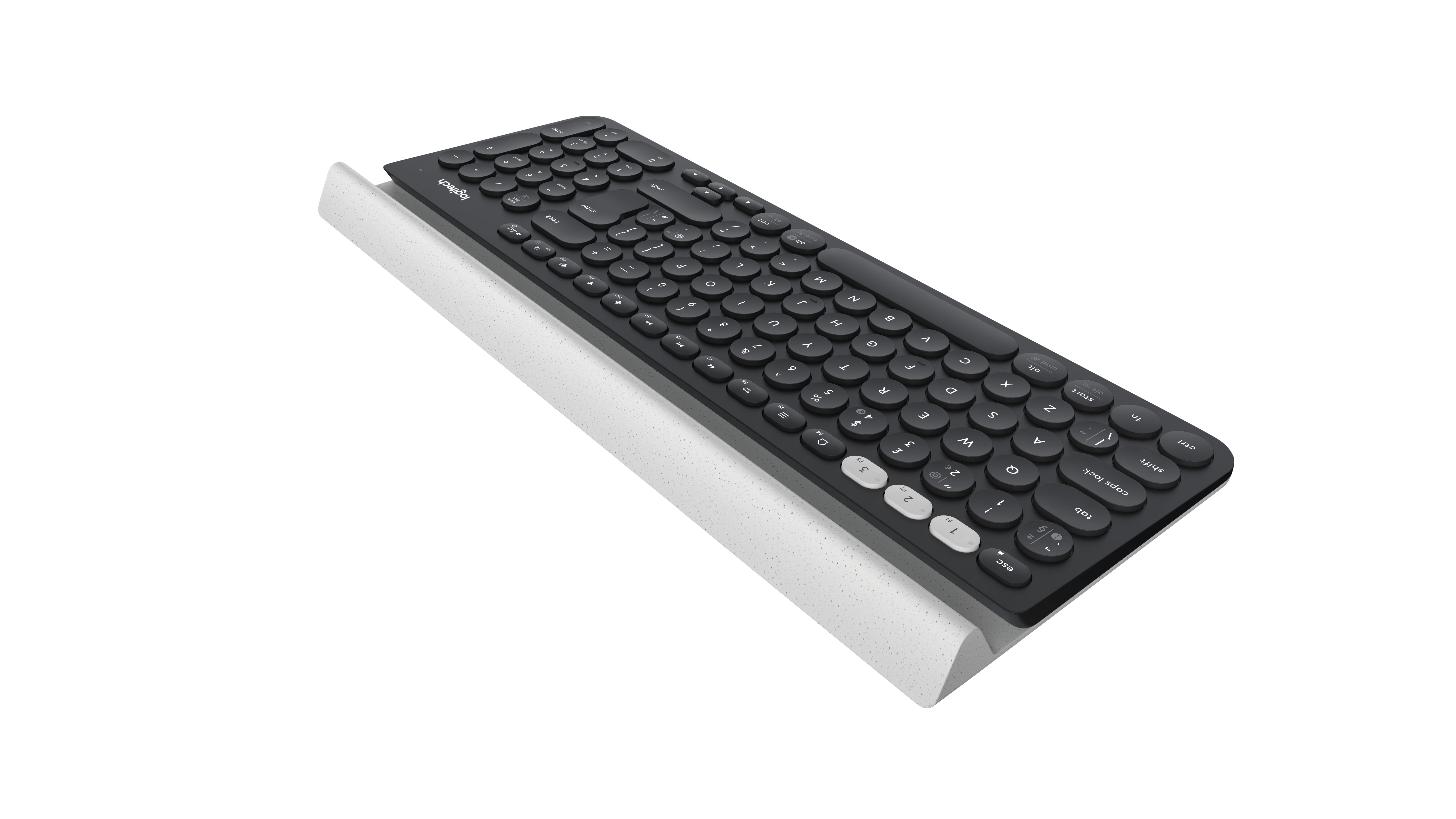 Een zwart computertoetsenbord met een polssteun. Het toetsenbord staat op een wit oppervlak.