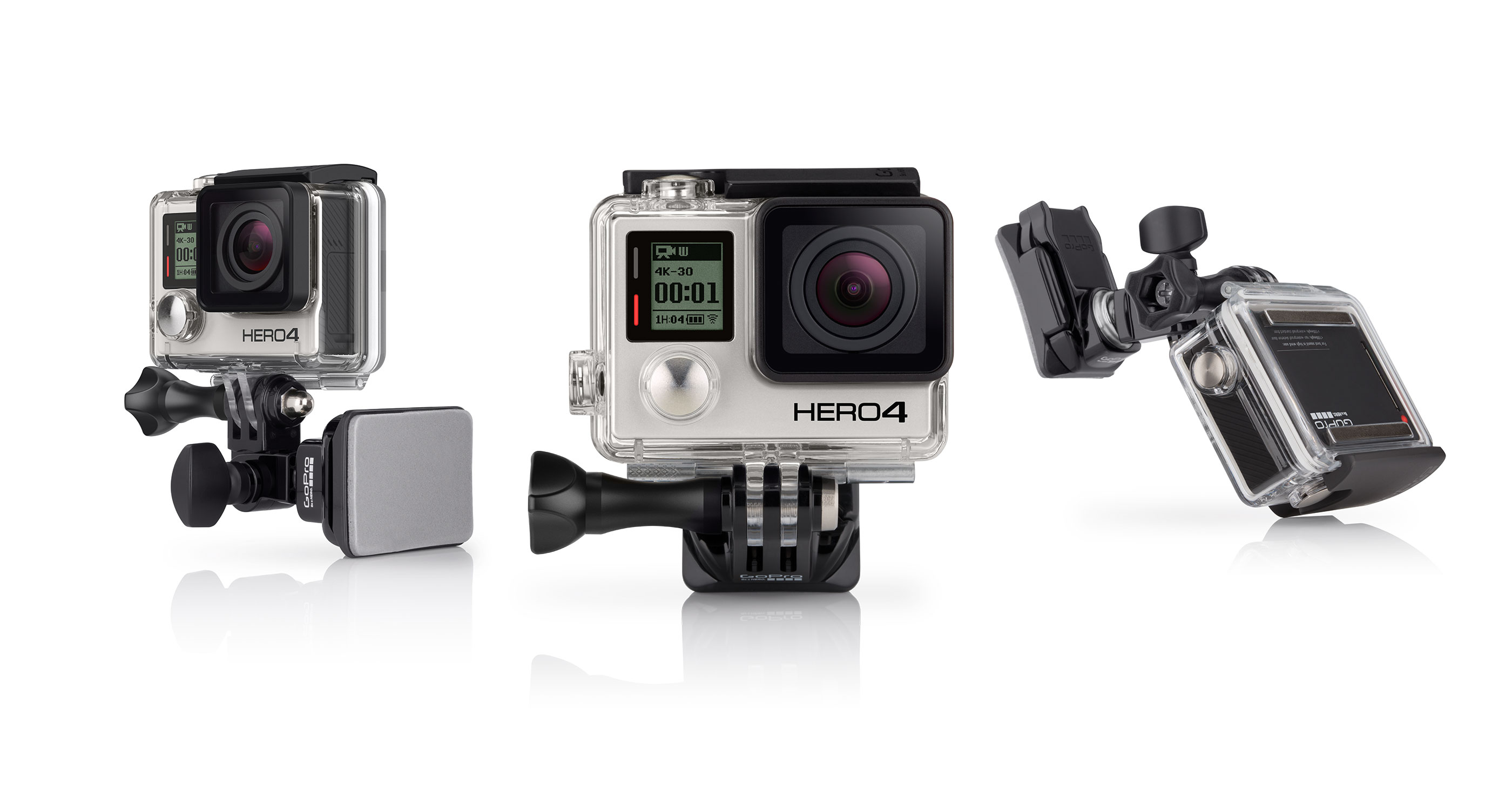 Drei GoPro HERO4 Kameras mit Halterungen. Sie sind silber und schwarz, zeigen Bildschirme, vor weißem Hintergrund.
