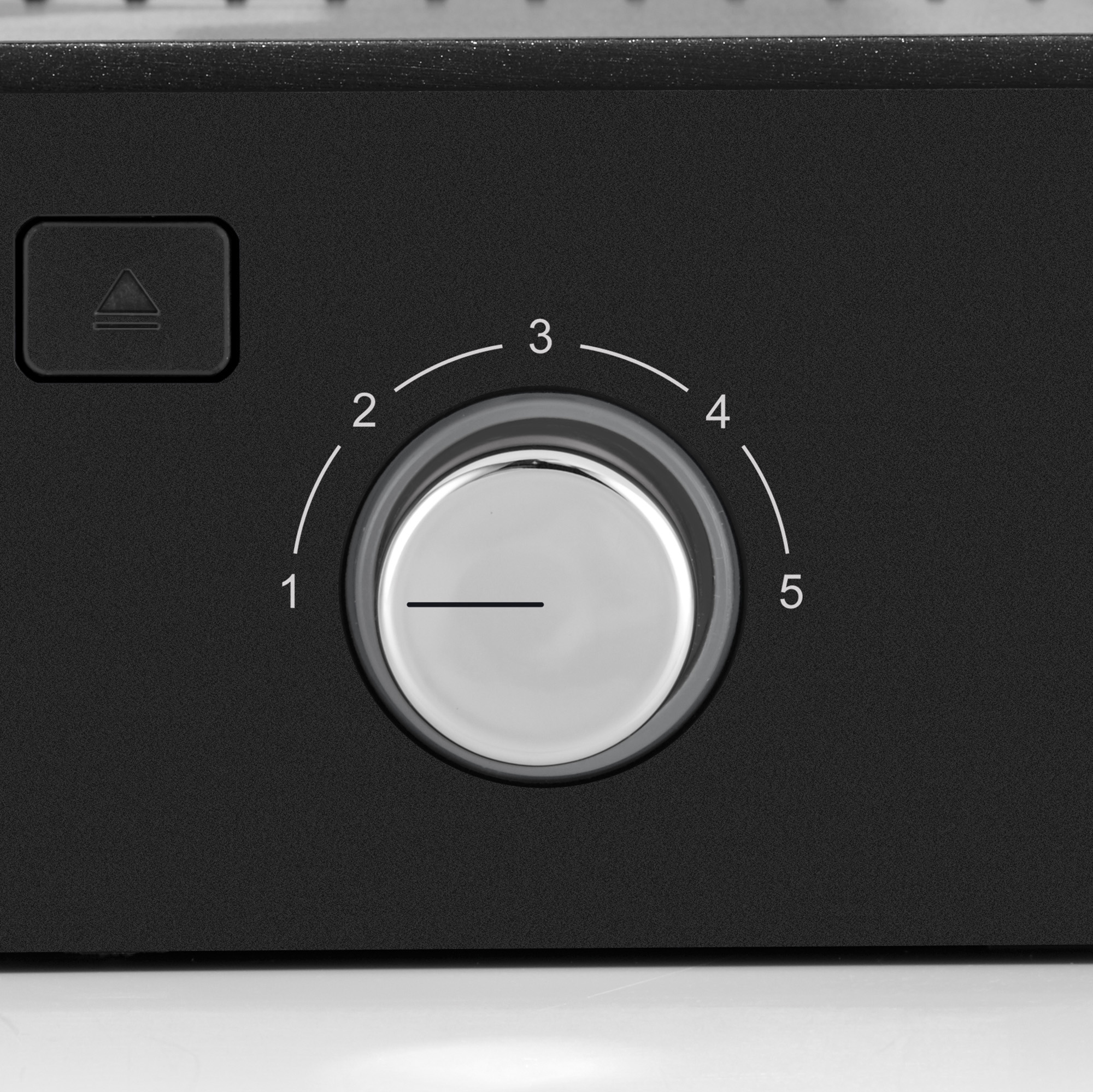 Un appareil noir avec un cadran argenté numéroté de 1 à 5 est montré.