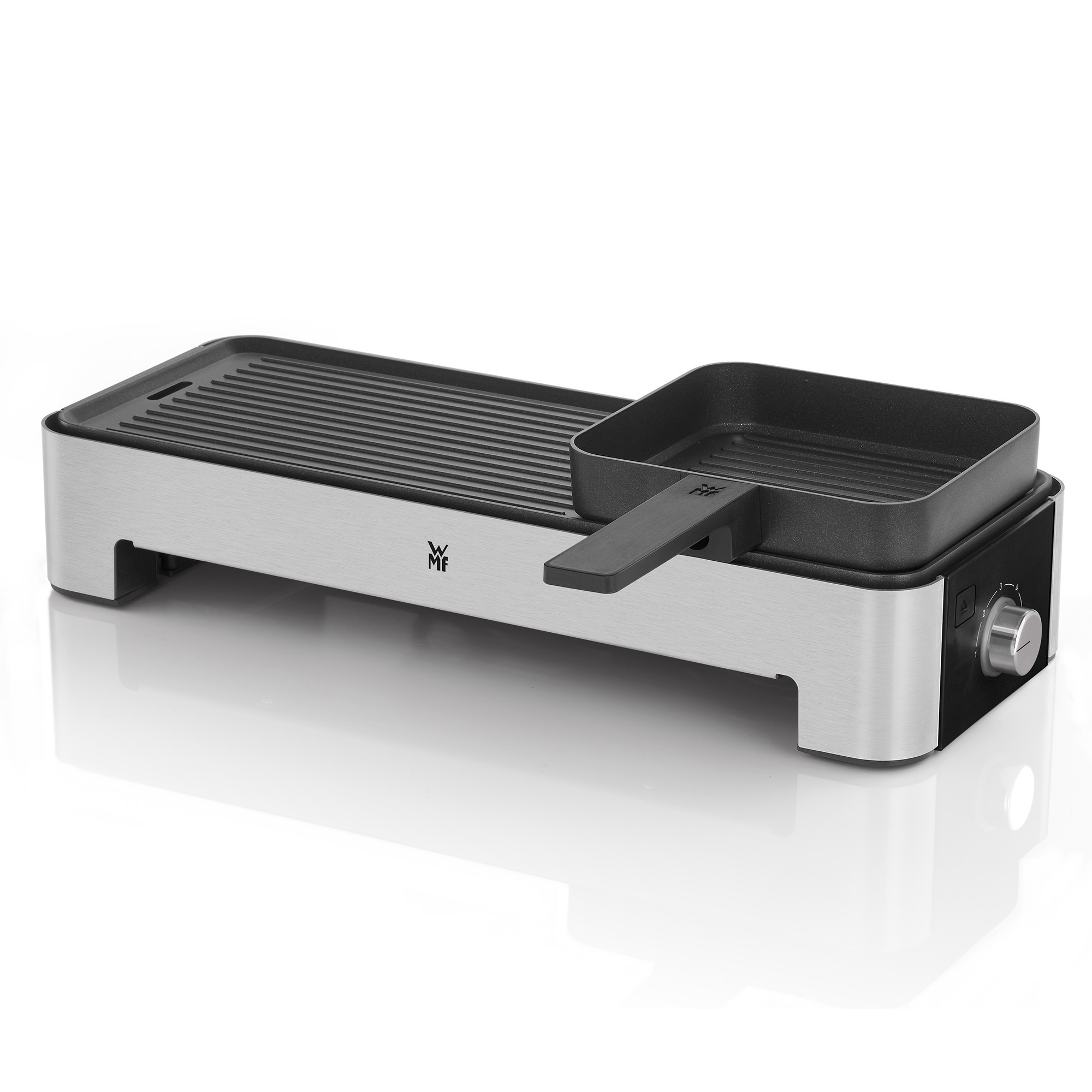 Gril argenté et noir. Il y a une poêle noire sur le gril. Fond blanc.