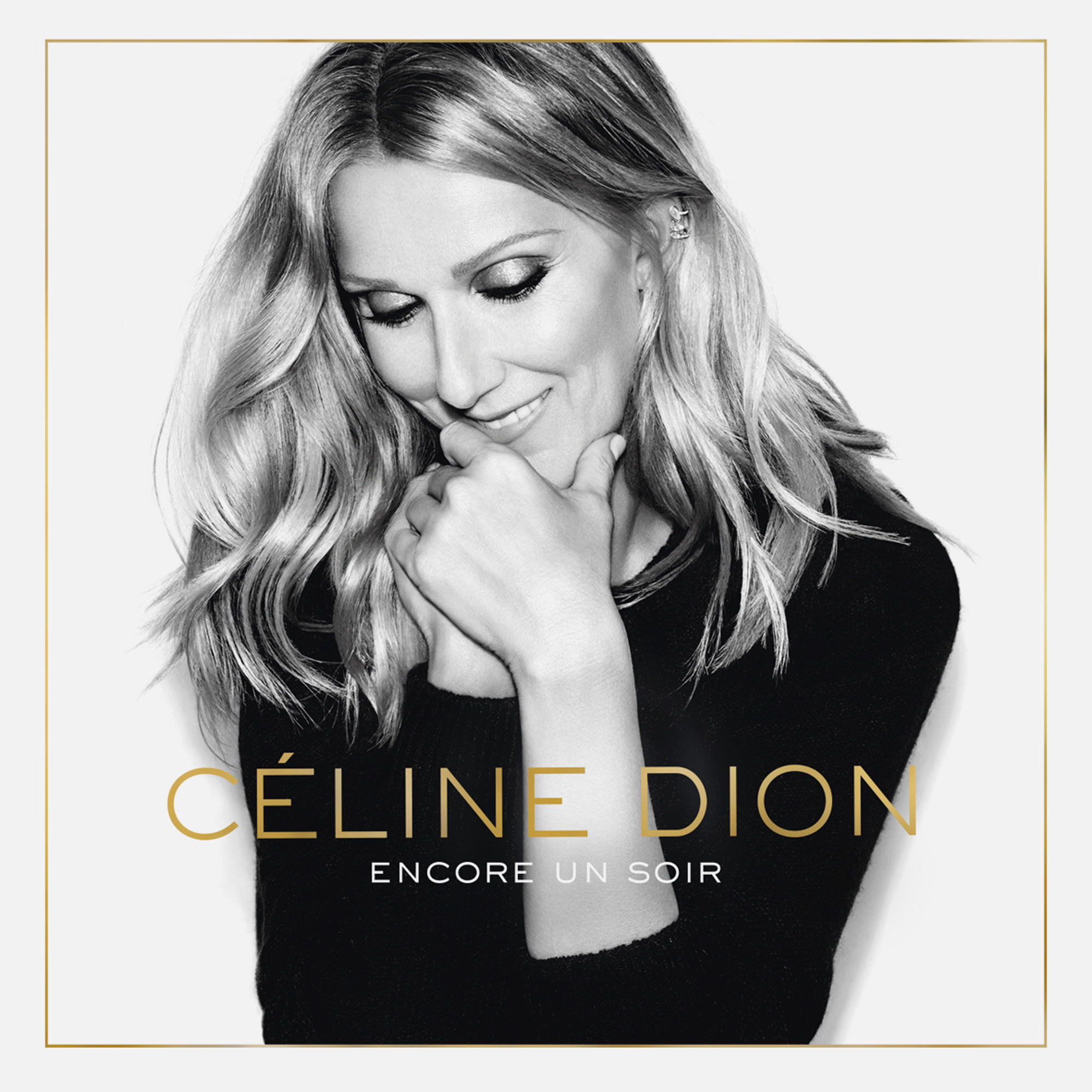 Egy fekete-fehér fotó Céline Dion-ról, amint mosolyog, arany szöveggel.