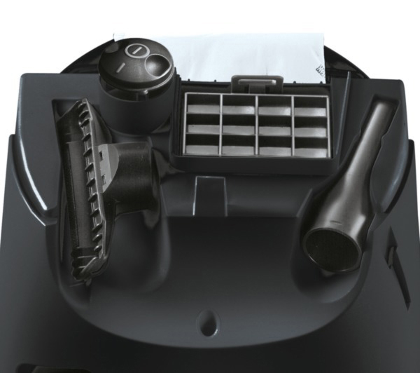 Das Innere eines schwarzen Staubsaugers mit sichtbarem Filter und Zubehör.