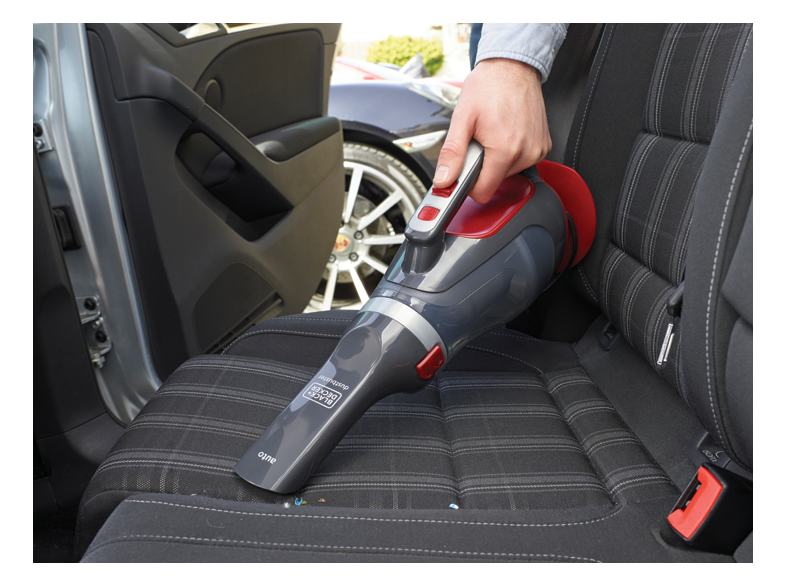 Személy porszívózza az autósülést egy BLACK+DECKER kézi porszívóval.