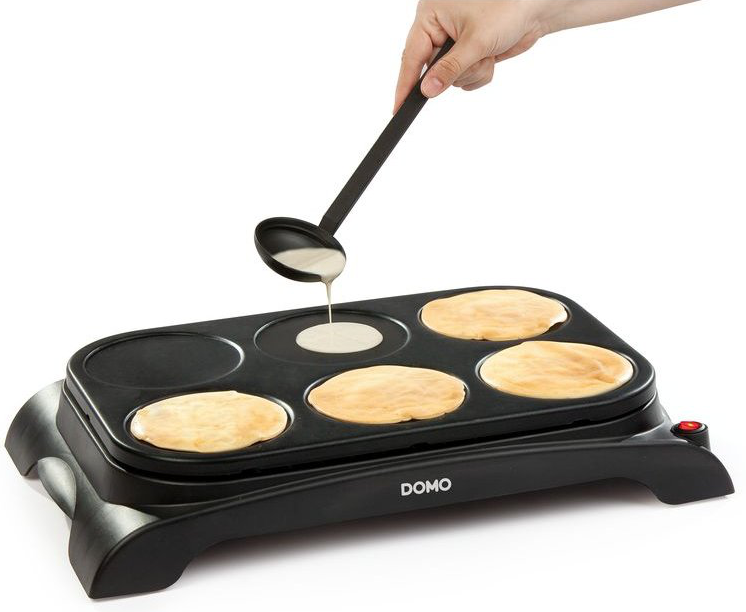 Une personne verse de la pâte sur une machine à faire des crêpes avec six cercles.