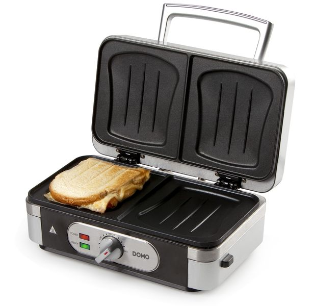 Appareil à sandwich avec un sandwich grillé à l'intérieur. L'appareil est ouvert sur fond blanc.