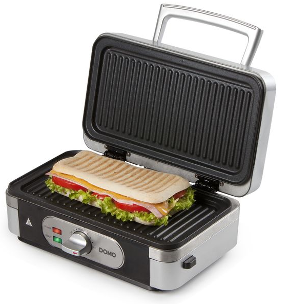Gril panini ouvert avec un sandwich à l'intérieur. Le gril est noir et argenté. Le sandwich contient fromage, tomate, laitue et viande.