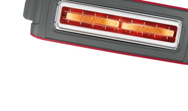 Ein rot-grauer Toaster mit zwei Brotscheiben darin.