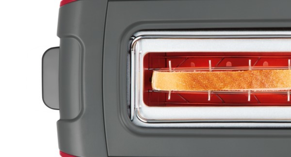 Nahaufnahme eines Toasters mit einer Scheibe Toastbrot, rotes Glühen sichtbar.