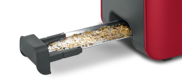Roter Toaster mit Krümeln in der Krümelschublade.