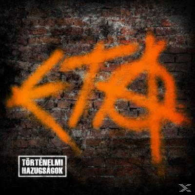 Graffiti egy téglán, narancs szöveggel és 'Törtenelmi Hazugságok' szavakkal.
