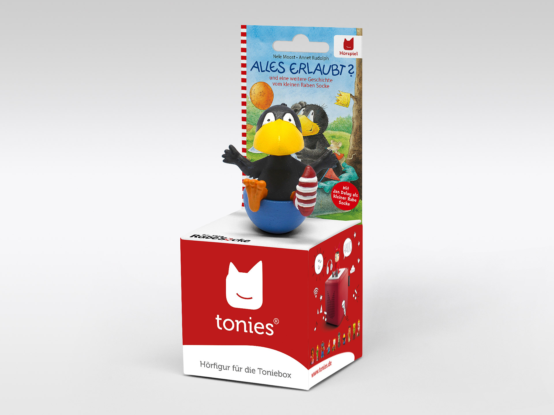 Eine Tonies-Box mit einem Rabenspielzeug oben. Das Spielzeug ist schwarz, mit gelbem Schnabel und blauem Sockel.