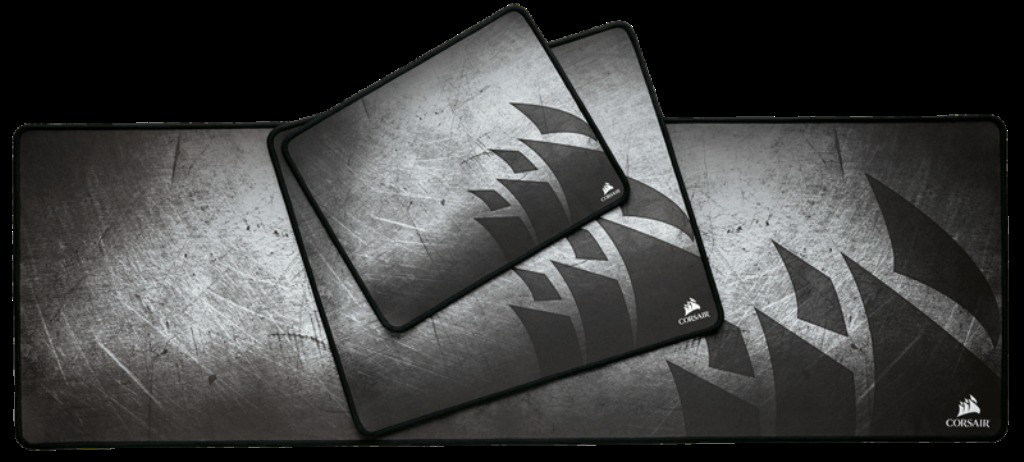 Drei schwarze Mauspads mit Corsair-Logo auf strukturiertem, grauem Hintergrund.