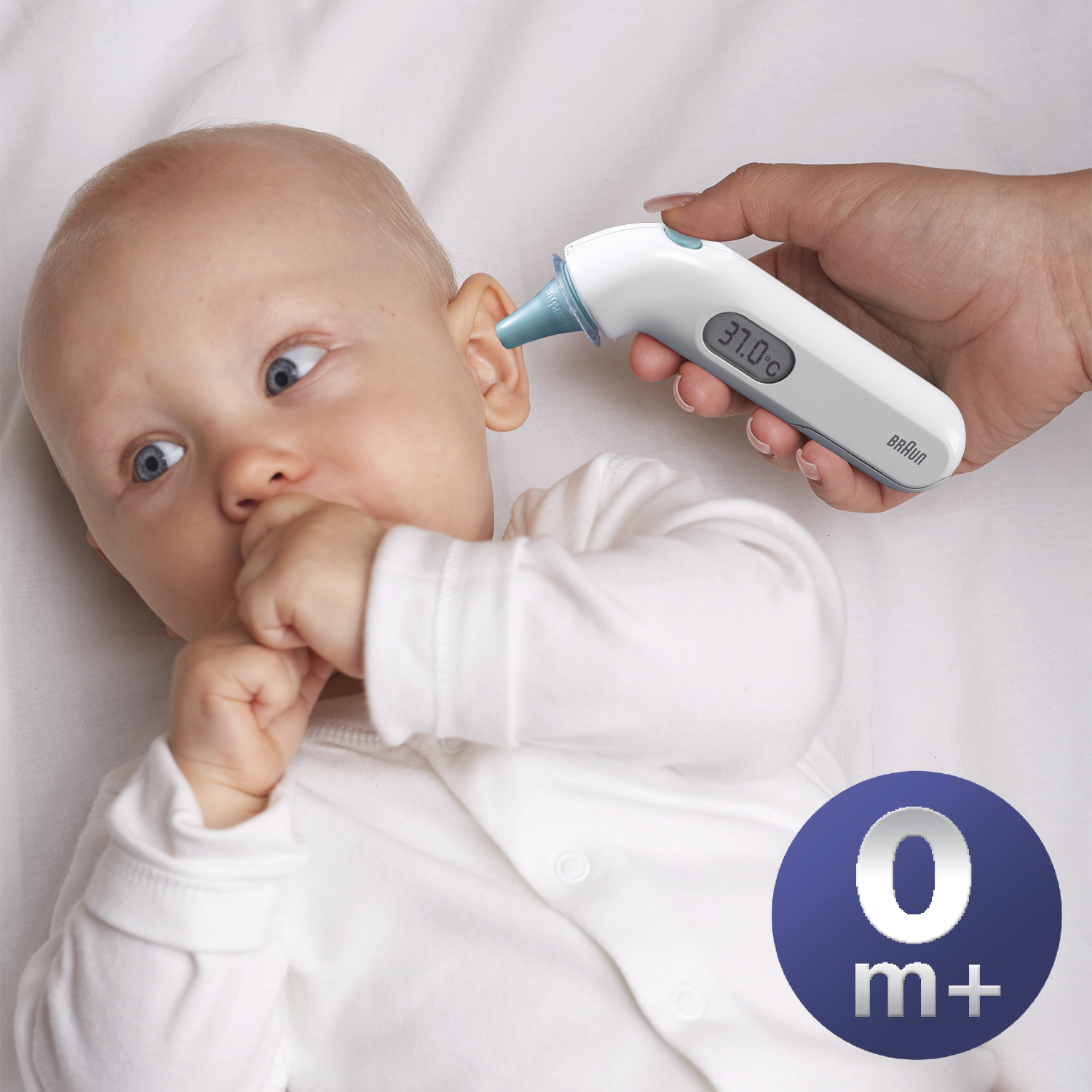 Baby wordt gecontroleerd met een digitale thermometer. De baby ligt op een wit laken. De thermometer heeft een blauwe punt.
