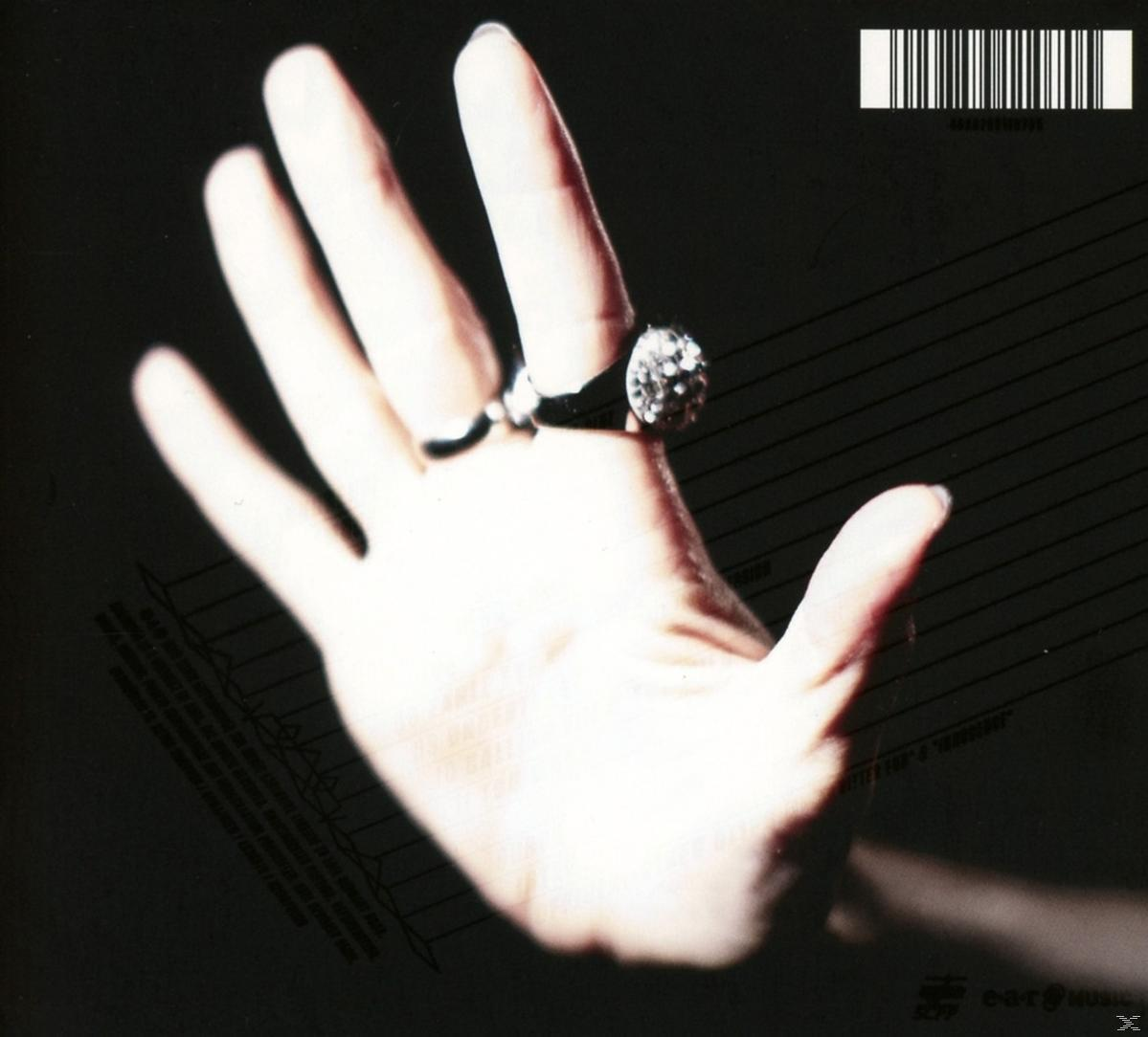 Hand mit Diamantring, schwarzer Hintergrund, Notenlinien.