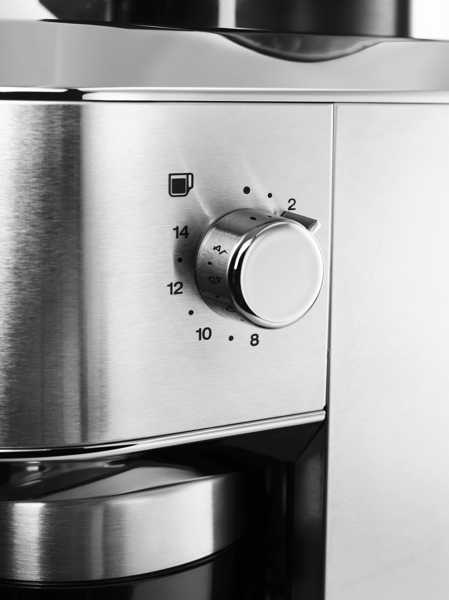 Nahaufnahme einer Kaffeemaschine aus Edelstahl. Ein Drehknopf mit Zahlen und einem Kaffeetassen-Symbol ist sichtbar.
