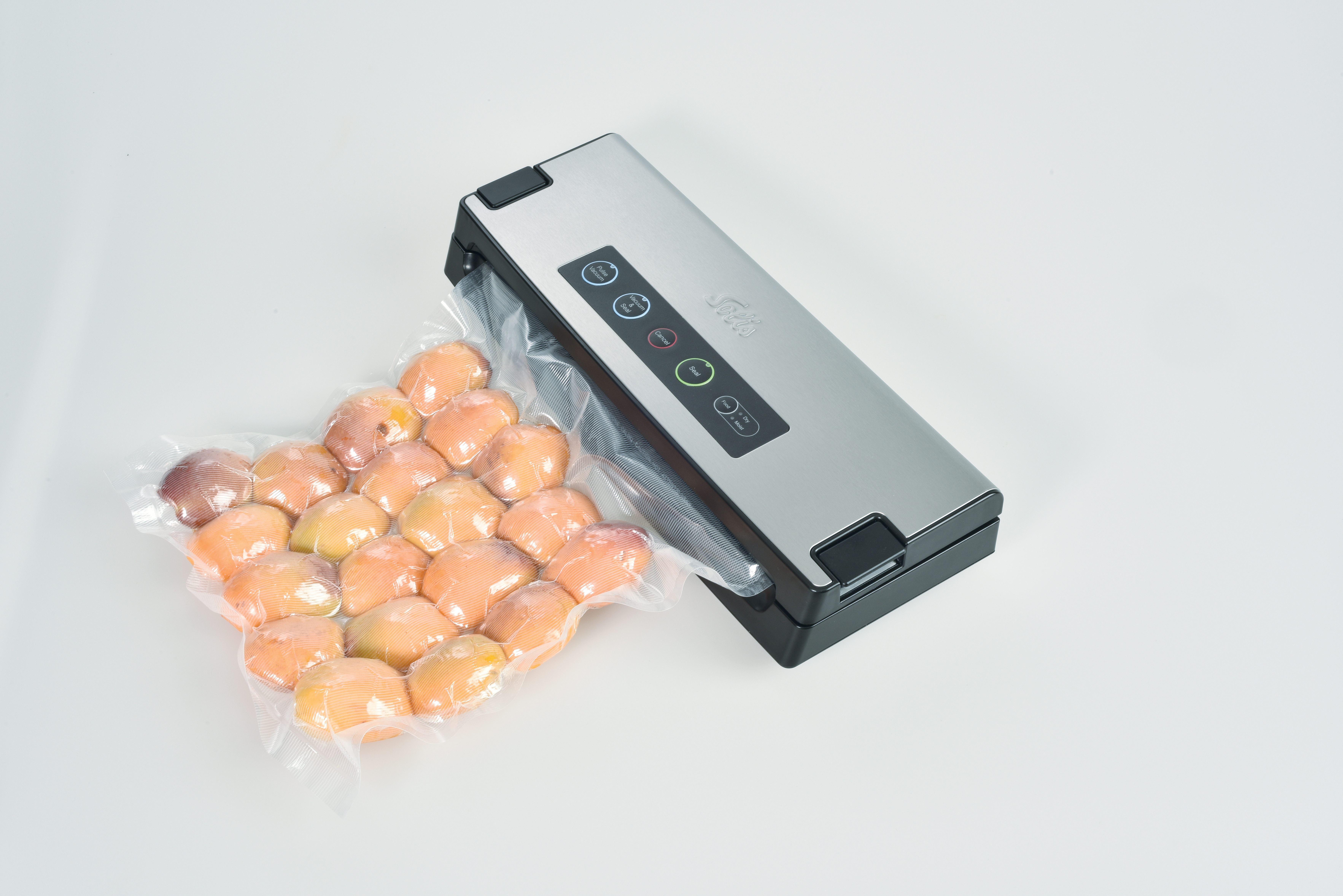 A vacuum sealer with a tray of vacuum-packed orange food items, possibly fish, on a white surface. The sealer is silver and black.