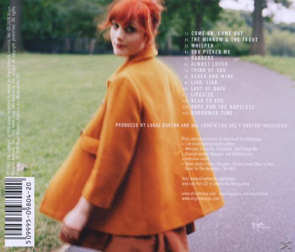 Albumcover mit einer Frau in einem orangefarbenen Mantel, die zurückblickt. Text auf der Rückseite, grüner Pfad.