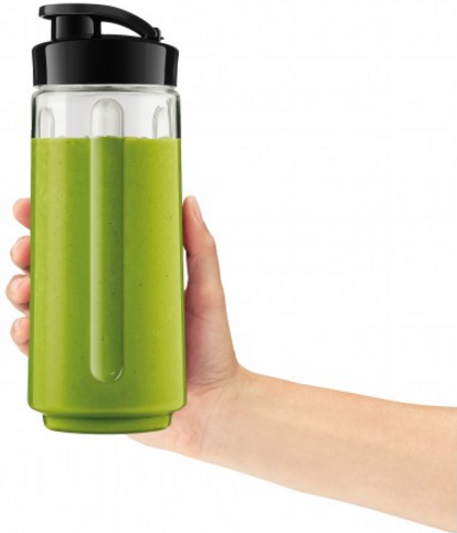 Main tenant un smoothie vert dans une bouteille transparente avec un bouchon noir, fond blanc.