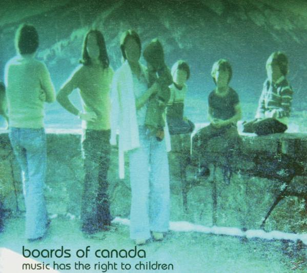 Gruppe von Menschen, einige halten ein Kind, stehen in der Nähe einer Mauer. Grünstich. Text unten: boards of canada, music has the right to children.
