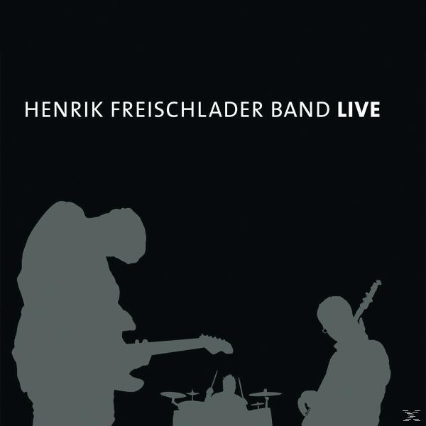 Schwarzer Hintergrund mit weißem Text: Henrik Freischlader Band Live, und Band-Silhouetten.