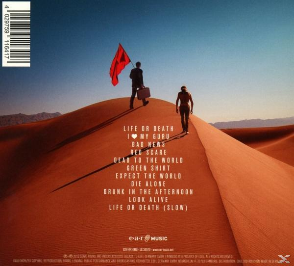 CD-Cover, zwei Männer auf einer Sanddüne. Rote Fahne, blauer Himmel.