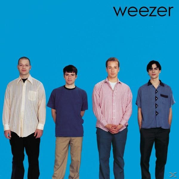 Band Weezer, vier Männer in verschiedenen Hemden auf blauem Hintergrund.
