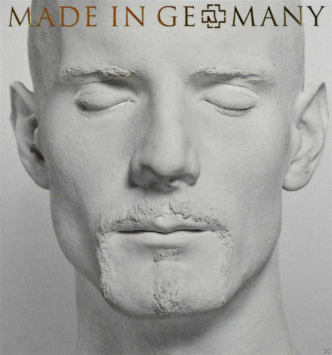 Gros plan d'un visage sculpté blanc d'un homme aux yeux fermés et à la barbe courte.
