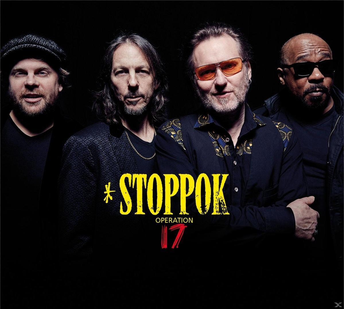Vier Bandmitglieder von *Stoppok Operation 17* posieren vor dunklem Hintergrund.