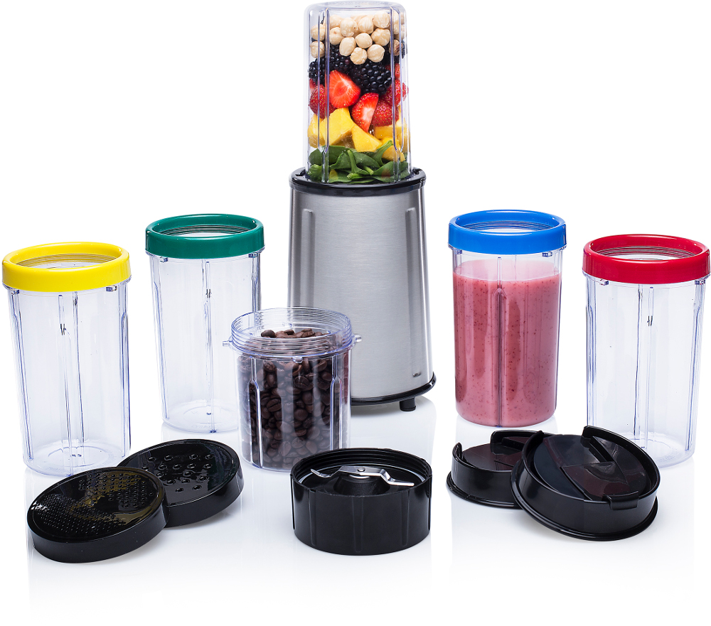 A blender with multiple cups and accessories. It contains mixed fruits and vegetables.