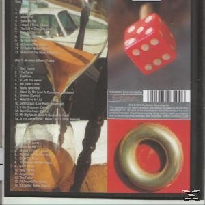 Album-Rückseite mit mehreren Bildern und Text, darunter ein roter Würfel und ein goldener Ring.