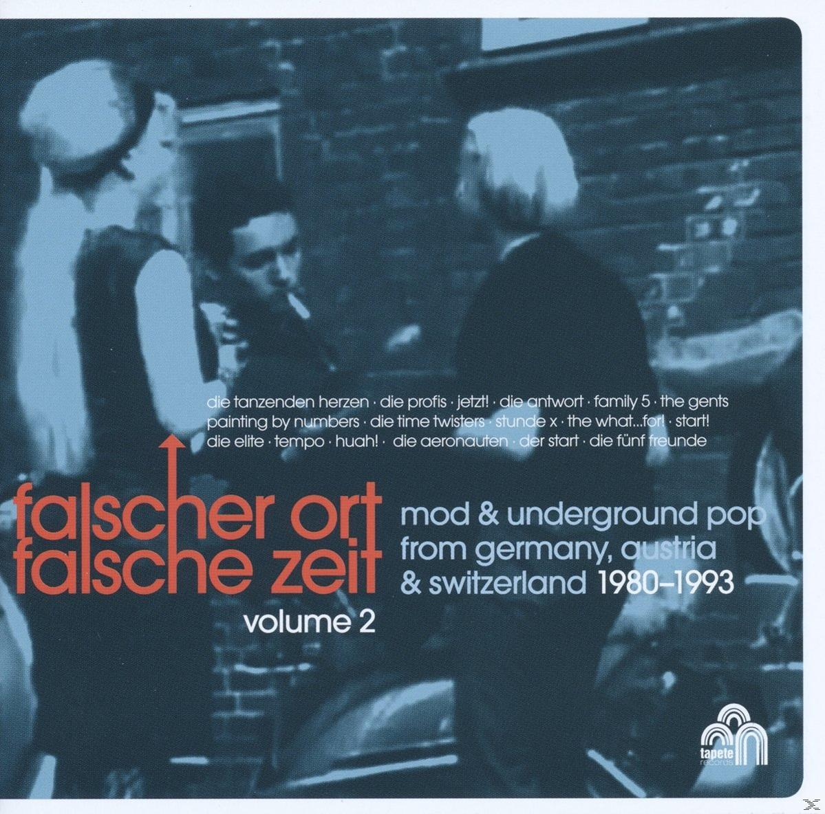 Albumcover mit Personen, Text auf Deutsch und Englisch. Der Titel lautet 'Falscher Ort Falsche Zeit'.
