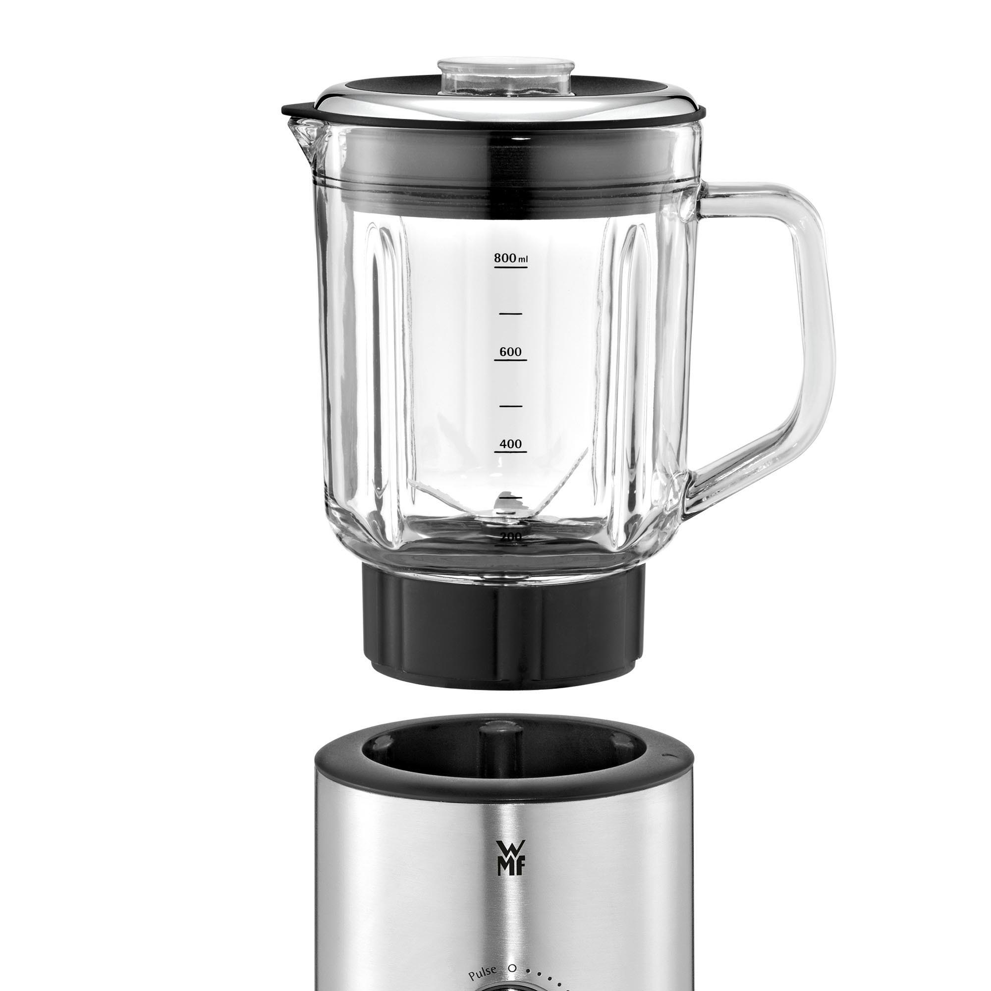 Mixer mit Glasbehälter und schwarzem Sockel. Edelstahlgehäuse. Weißer Hintergrund.