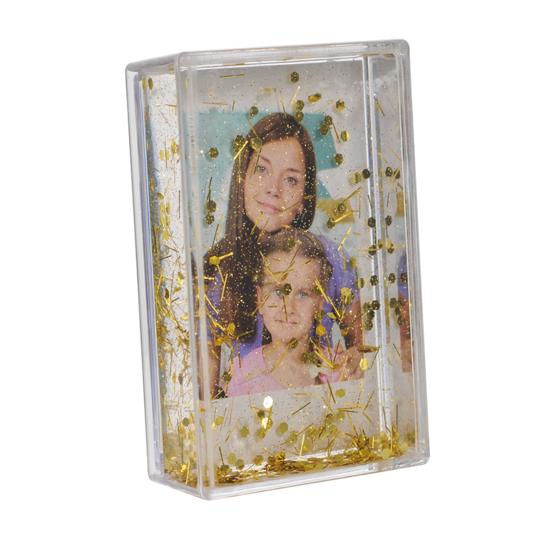 Ein klarer Rahmen mit einem Bild von zwei Frauen und goldenem Glitzer darum herum.