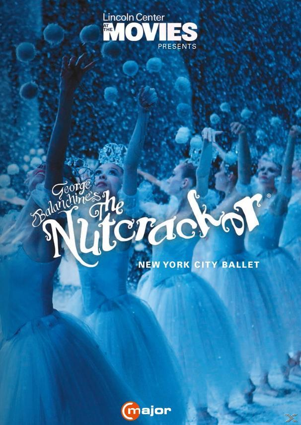 Balletttänzerinnen in weißen Tutus treten auf. Schnee fällt mit blauem Hintergrund.