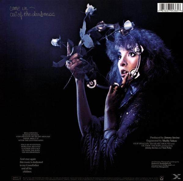 Stevie Nicks auf einem Plattencover, Blumen haltend. Dunkler Hintergrund. Der Text 'Come in out of the darkness' ist vorhanden.