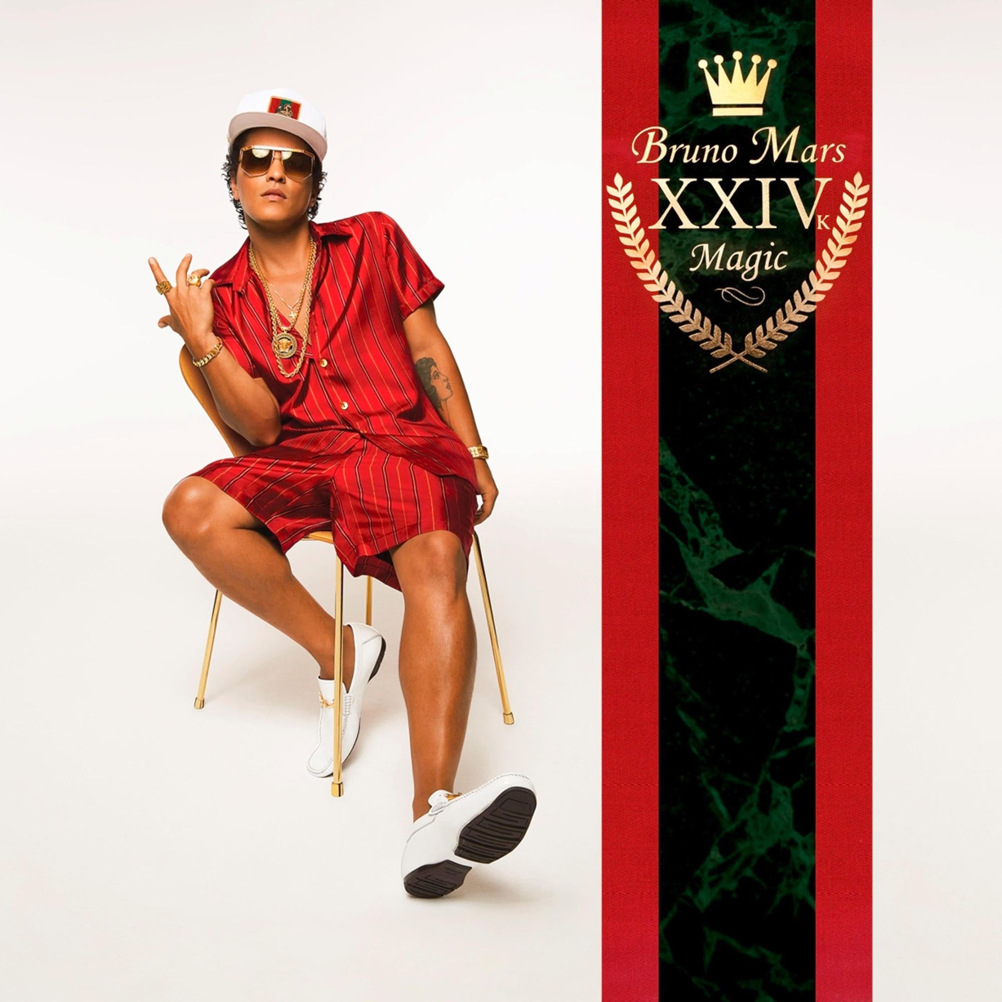 Bruno Mars in rotem Outfit, sitzend, mit goldenem Kronenlogo.