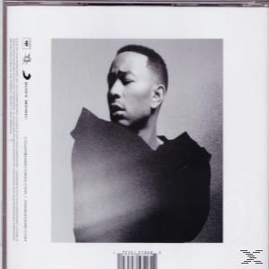 Schwarz-Weiß-Bild von John Legend. Er schaut nach unten und trägt ein dunkles Oberteil. Der Hintergrund ist schlicht.