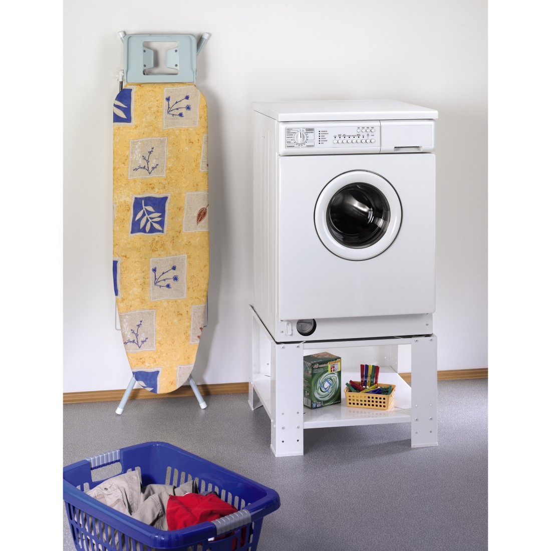 Laundry room with washing machine, ironing board, and a blue basket.