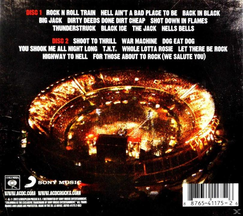 Pochette de CD avec listes de titres de chansons. Image d'un stade la nuit. Comprend un logo et du texte en bas.